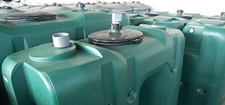 Groene kunststof regenwatertanks met aansluitingen en mangaten voor efficiënte wateropslag en hergebruik.